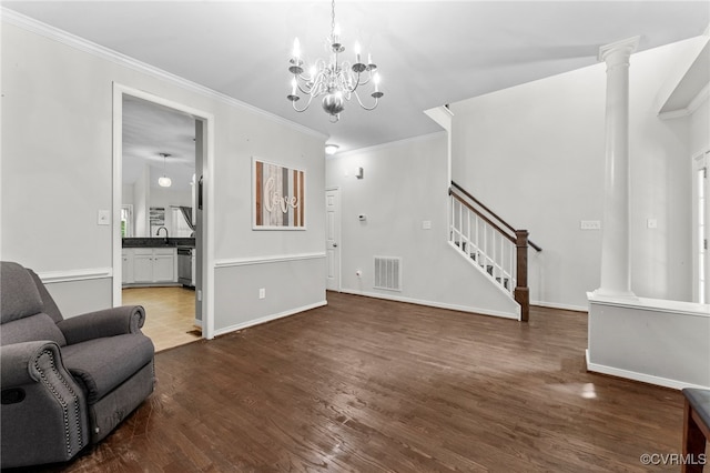5129 Jenkins Forest Ln, Sandston, VA 23150 - living room featuring crown molding, stairs, wood finished floors, decorative columns, and a chandelier