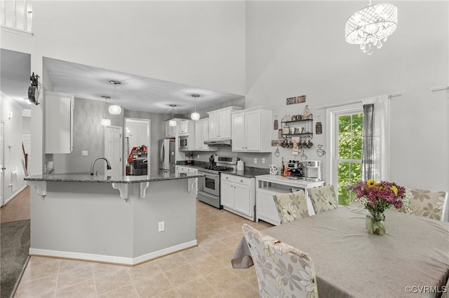 5129 Jenkins Forest Ln, Sandston, VA 23150 - kitchen featuring stainless steel appliances, a towering ceiling, a peninsula, white cabinets, and a kitchen bar
