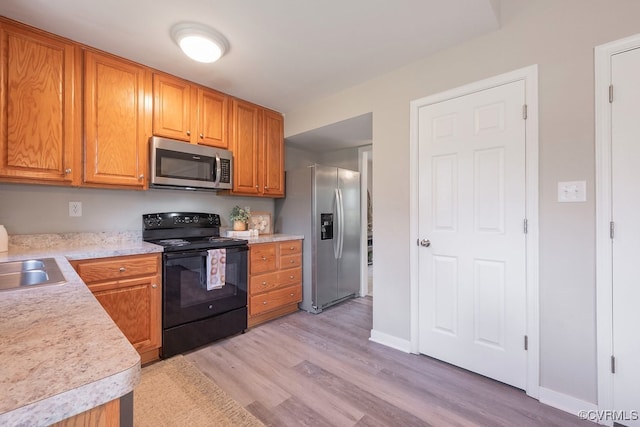 1014 Pennsylvania Ave, Glen Allen, VA 23060 - kitchen featuring appliances with stainless steel finishes, light countertops, light wood-type flooring, and brown cabinets