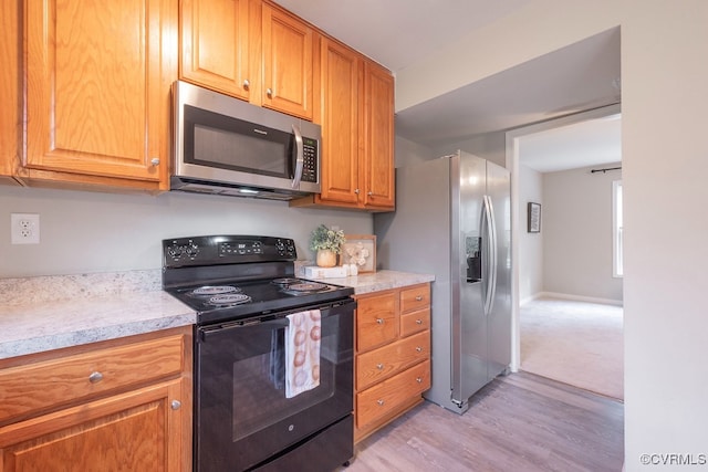 1014 Pennsylvania Ave, Glen Allen, VA 23060 - kitchen with appliances with stainless steel finishes, light wood-style flooring, and brown cabinetry