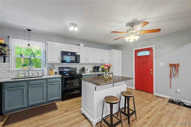 4606 S Run Ct, Chesterfield, VA 23234 - kitchen with black appliances, tasteful backsplash, light wood-style flooring, and a kitchen breakfast bar