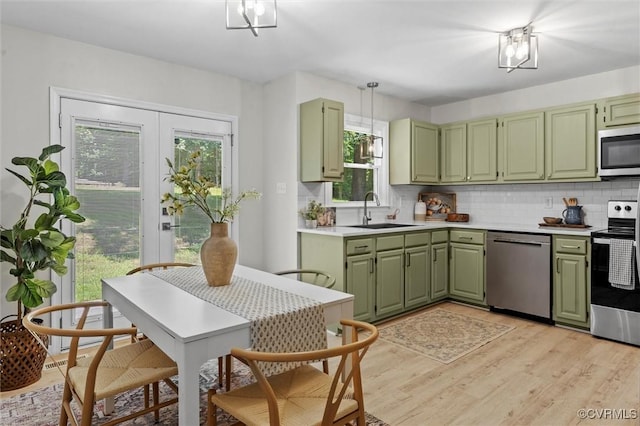 1900 Pine Creek Bluff Ct, Powhatan, VA 23139 - kitchen with stainless steel appliances, green cabinets, light wood-type flooring, light countertops, and decorative backsplash