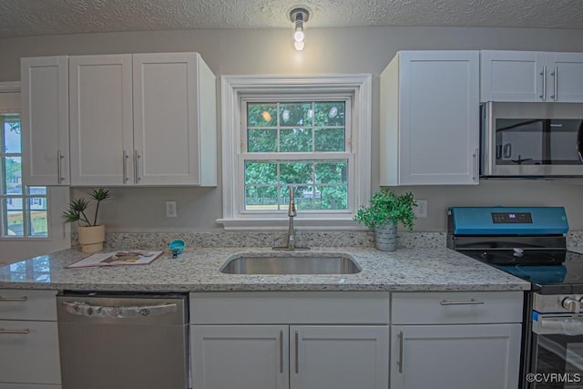 1300 Hyner Cir, Sandston, VA 23231 - kitchen featuring appliances with stainless steel finishes, white cabinets, light stone countertops, and a textured ceiling
