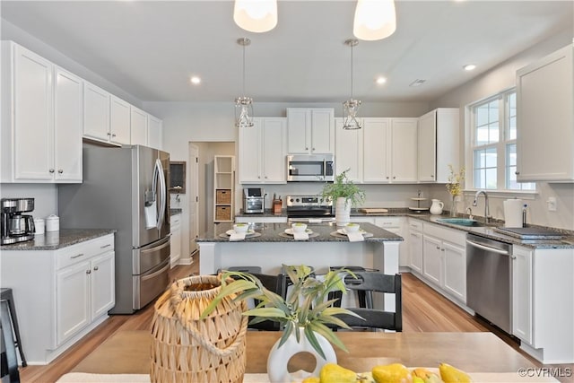3636 Knighton Cir, Midlothian, VA 23112 - kitchen featuring appliances with stainless steel finishes, a center island, white cabinets, light wood finished floors, and dark stone countertops