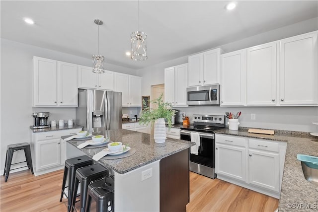 3636 Knighton Cir, Midlothian, VA 23112 - kitchen featuring appliances with stainless steel finishes, white cabinets, light wood-type flooring, dark stone counters, and recessed lighting