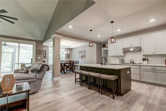 3016 Maple Grove Ln, Powhatan, VA 23139 - kitchen with under cabinet range hood, recessed lighting, ornate columns, a ceiling fan, and a kitchen bar