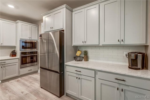 3016 Maple Grove Ln, Powhatan, VA 23139 - kitchen with appliances with stainless steel finishes, decorative backsplash, light wood finished floors, light stone counters, and recessed lighting