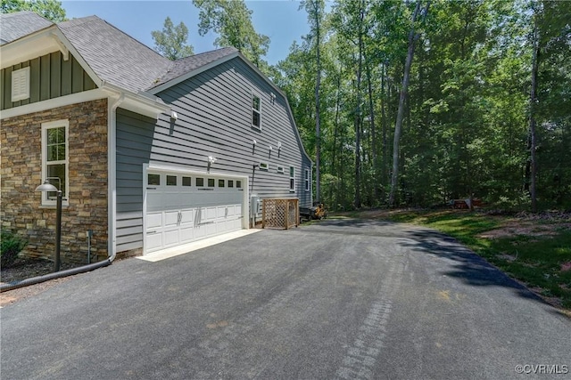 3016 Maple Grove Ln, Powhatan, VA 23139 - view of side of home featuring stone siding, driveway, board and batten siding, and a shingled roof
