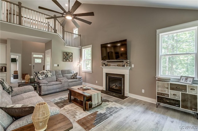 3016 Maple Grove Ln, Powhatan, VA 23139 - living room with ceiling fan, light wood finished floors, healthy amount of natural light, high vaulted ceiling, and a glass covered fireplace