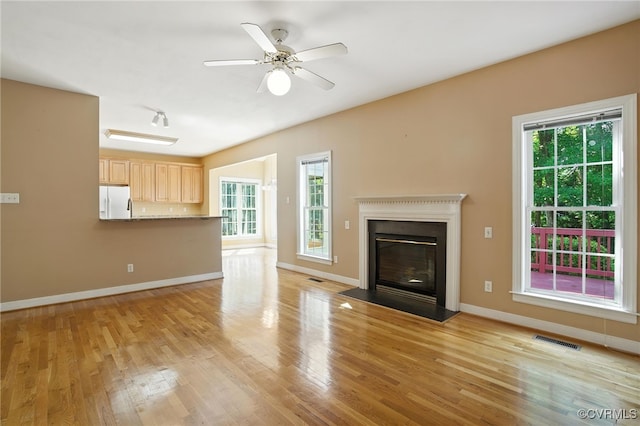 8248 Hampton Arbor Cir, Chesterfield, VA 23832 - unfurnished living room with healthy amount of natural light, light wood finished floors, a fireplace with flush hearth, and ceiling fan