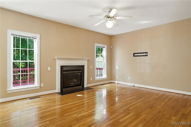 8248 Hampton Arbor Cir, Chesterfield, VA 23832 - unfurnished living room with plenty of natural light, light wood-type flooring, a fireplace with flush hearth, and a ceiling fan