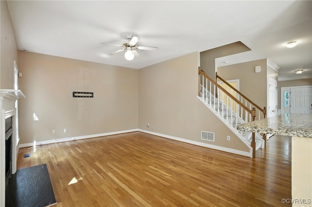 8248 Hampton Arbor Cir, Chesterfield, VA 23832 - unfurnished living room featuring ceiling fan, stairway, light wood finished floors, a fireplace with flush hearth, and ornamental molding