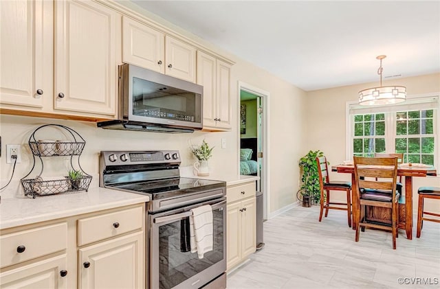5773 S Jessup Rd, Chesterfield, VA 23832 - kitchen featuring appliances with stainless steel finishes, cream cabinetry, light countertops, light marble finish floors, and decorative light fixtures