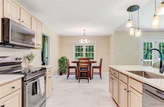 5773 S Jessup Rd, Chesterfield, VA 23832 - kitchen with stainless steel appliances, cream cabinets, light countertops, and pendant lighting