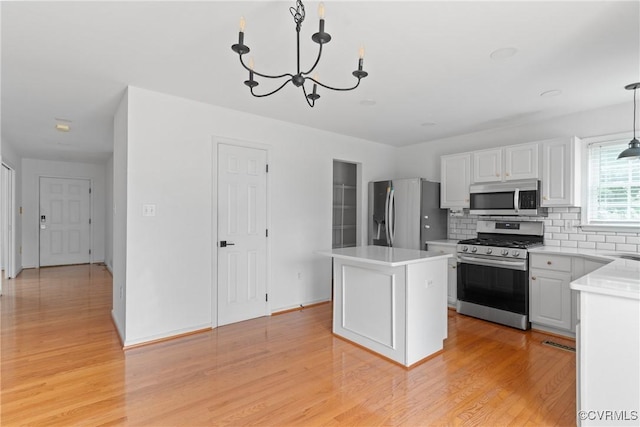 5413 Cranston Ct, Henrico, VA 23059 - kitchen with appliances with stainless steel finishes, a kitchen island, light wood-style floors, backsplash, and light countertops