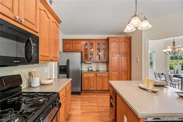 6125 Trinity Church Rd, Dinwiddie, VA 23833 - kitchen featuring a chandelier, black appliances, light wood-style flooring, and brown cabinets