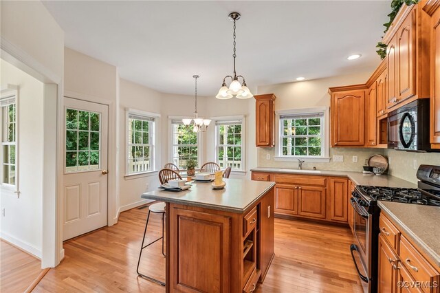 6125 Trinity Church Rd, Dinwiddie, VA 23833 - kitchen with stainless steel gas range, black microwave, a chandelier, light wood-style flooring, and recessed lighting