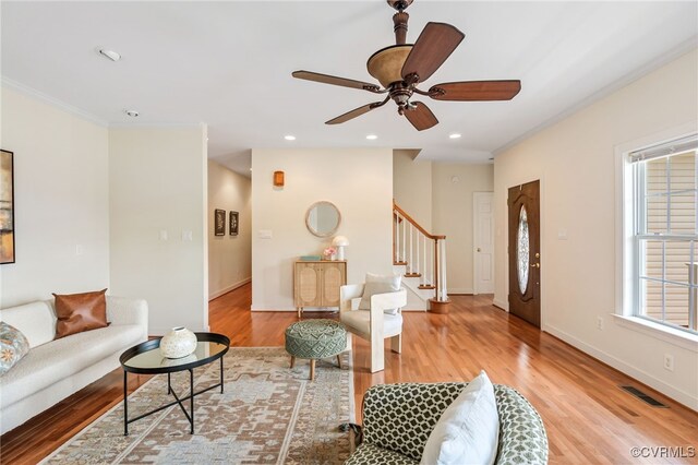 6125 Trinity Church Rd, Dinwiddie, VA 23833 - living area with stairway, plenty of natural light, light wood finished floors, ceiling fan, and crown molding