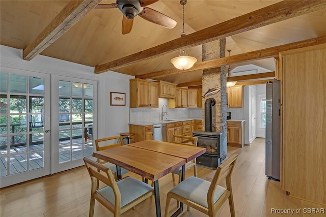186 Bay Shore Point Rd, Port Haywood, VA 23138 - dining space featuring a wood stove, ceiling fan, light wood-style flooring, and healthy amount of natural light