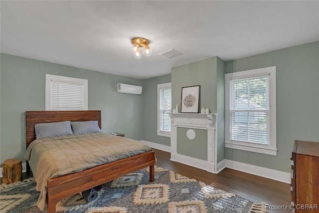 186 Bay Shore Point Rd, Port Haywood, VA 23138 - bedroom featuring a wall unit AC and dark wood finished floors