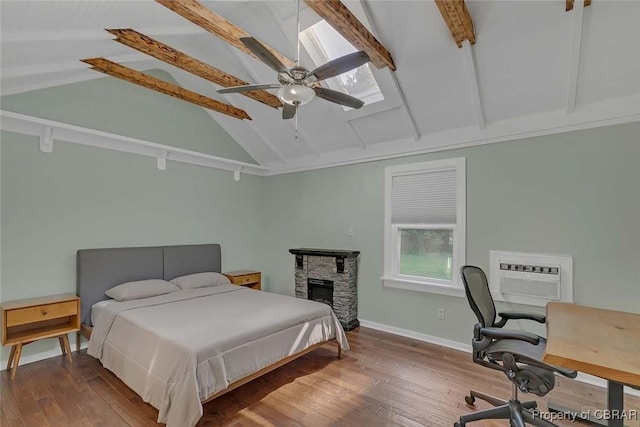 186 Bay Shore Point Rd, Port Haywood, VA 23138 - bedroom with beamed ceiling, wood finished floors, a desk, a stone fireplace, and ceiling fan