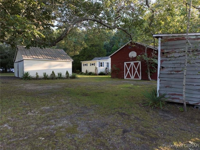 186 Bay Shore Point Rd, Port Haywood, VA 23138 - view of green lawn featuring an outdoor structure and a barn