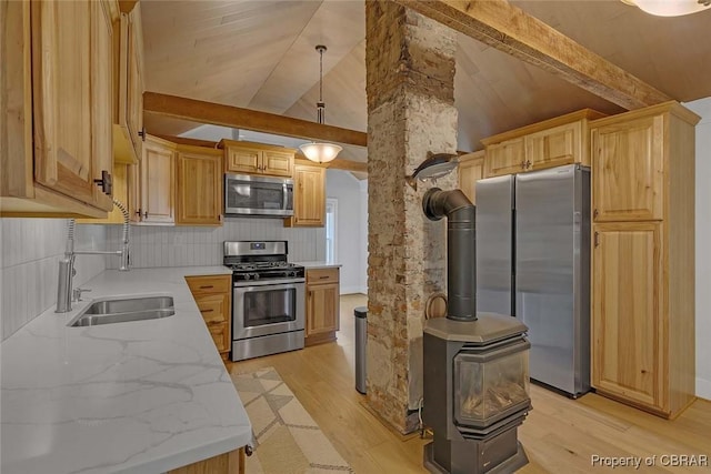 186 Bay Shore Point Rd, Port Haywood, VA 23138 - kitchen with appliances with stainless steel finishes, light wood-style floors, decorative backsplash, a wood stove, and light stone countertops