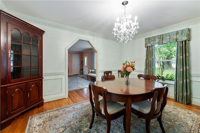 4310 Courthouse Rd, Prince George, VA 23875 - dining space featuring arched walkways, a chandelier, light wood-type flooring, ornamental molding, and a decorative wall
