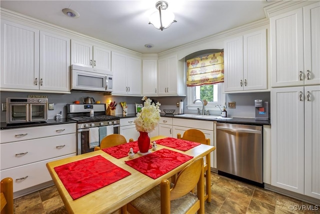 4310 Courthouse Rd, Prince George, VA 23875 - kitchen featuring appliances with stainless steel finishes, stone finish floors, dark countertops, and white cabinetry