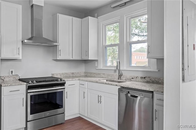 3406 Lawson St, Richmond, VA 23224 - kitchen featuring stainless steel appliances, wall chimney exhaust hood, white cabinets, and light stone countertops