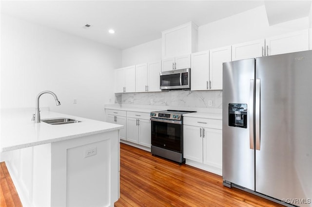 521 S Sycamore St, Petersburg, VA 23803 - kitchen with appliances with stainless steel finishes, decorative backsplash, light wood-type flooring, white cabinetry, and recessed lighting