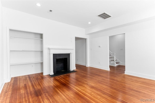 521 S Sycamore St, Petersburg, VA 23803 - unfurnished living room with stairs, a fireplace, hardwood / wood-style flooring, built in shelves, and recessed lighting