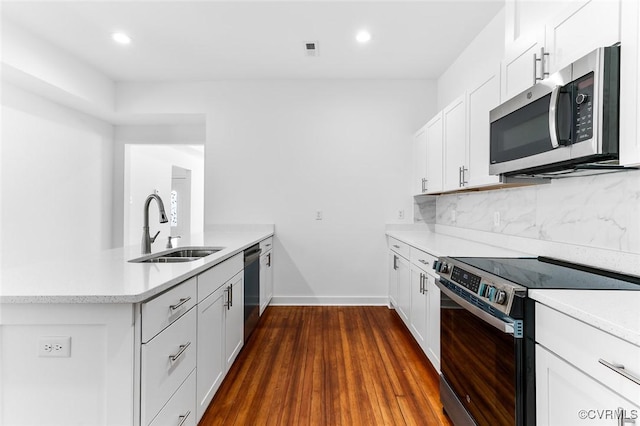 521 S Sycamore St, Petersburg, VA 23803 - kitchen with appliances with stainless steel finishes, a peninsula, light countertops, white cabinetry, and decorative backsplash