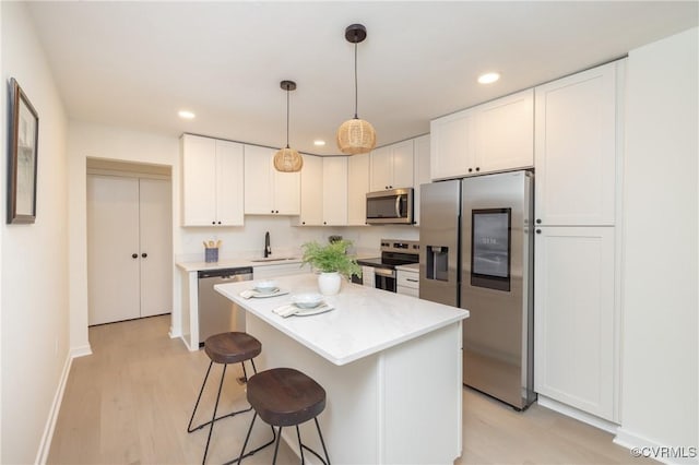 3211 Fox Chase Dr, Midlothian, VA 23112 - kitchen featuring appliances with stainless steel finishes, recessed lighting, white cabinets, a kitchen breakfast bar, and a center island