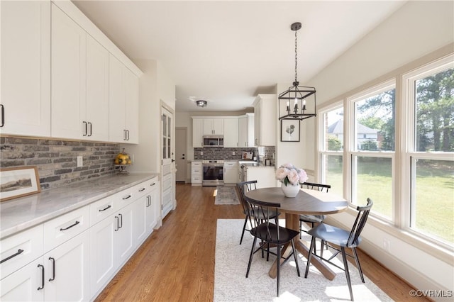 10703 Kriserin Cir, Chester, VA 23831 - dining area with healthy amount of natural light, light wood-type flooring, and a chandelier