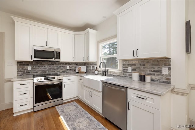 10703 Kriserin Cir, Chester, VA 23831 - kitchen with appliances with stainless steel finishes, wood finished floors, backsplash, white cabinets, and light stone counters