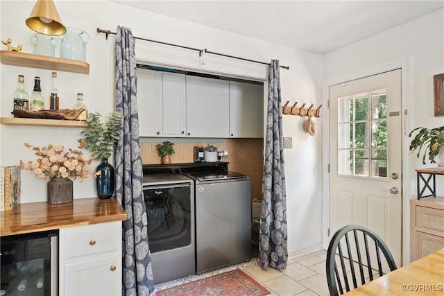 7085 Foxlair Dr, Mechanicsville, VA 23111 - laundry room featuring beverage cooler, washing machine and clothes dryer, light tile patterned flooring, and cabinet space