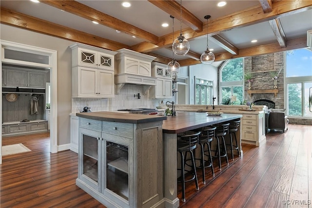 3300 Riverglade Rd, Powhatan, VA 23139 - kitchen with premium range hood, dark wood-style flooring, a large island with sink, a fireplace, and decorative backsplash