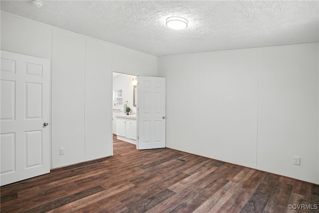 209 Oak Hill Rd, Prospect, VA 23960 - unfurnished bedroom with dark wood finished floors, a textured ceiling, and a decorative wall
