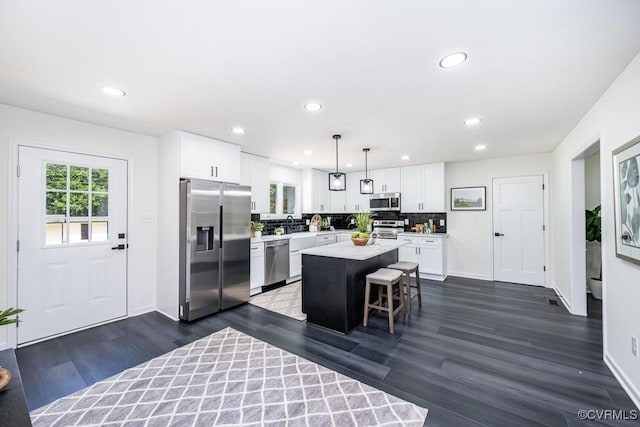 2629 Maidens Rd, Powhatan, VA 23139 - kitchen featuring appliances with stainless steel finishes, light countertops, a kitchen island, white cabinets, and tasteful backsplash