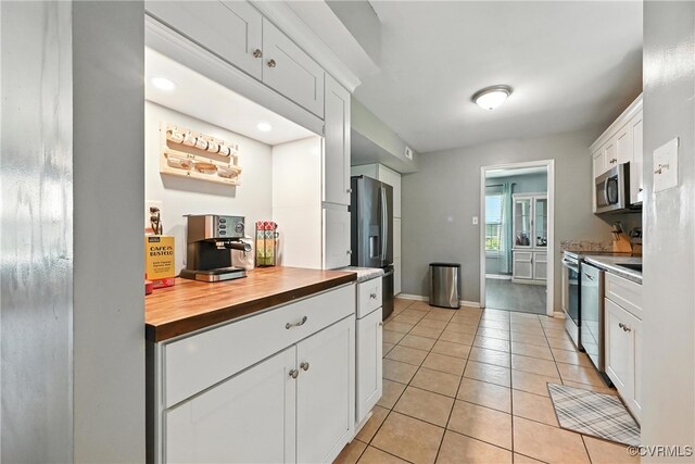 16731 Amherst Oak Ln, Chesterfield, VA 23834 - kitchen with appliances with stainless steel finishes, butcher block counters, light tile patterned flooring, and white cabinetry
