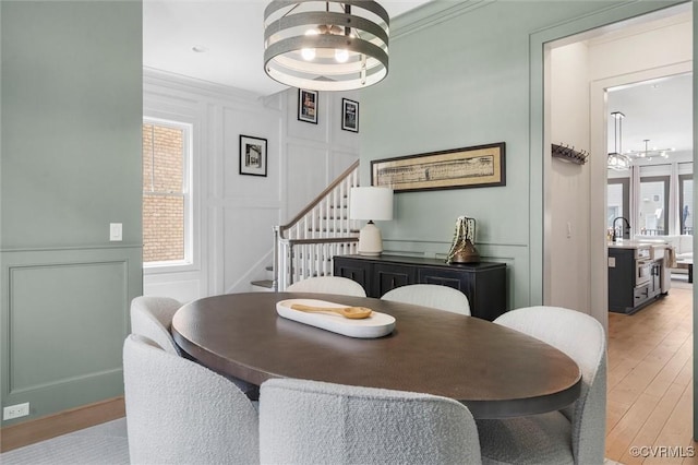 12340 Purbrook Walk, Henrico, VA 23233 - dining room featuring a decorative wall, stairway, light wood-type flooring, a chandelier, and crown molding