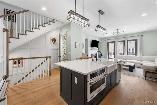 12340 Purbrook Walk, Henrico, VA 23233 - kitchen featuring open floor plan, dark cabinetry, oven, light wood-type flooring, and pendant lighting