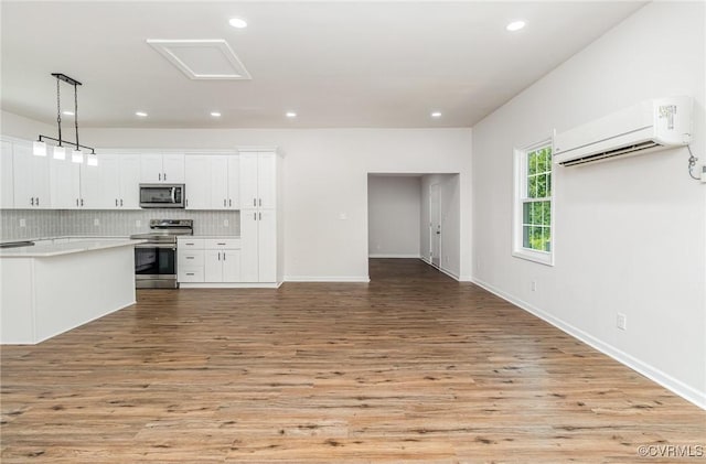 24 Hummingbird Ln, Cumberland, VA 23040 - kitchen featuring appliances with stainless steel finishes, a wall mounted AC, light wood-style flooring, light countertops, and open floor plan