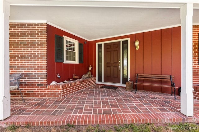 77 Kent Cove Rd, Kilmarnock, VA 22482 - view of exterior entry with board and batten siding, covered porch, and brick siding