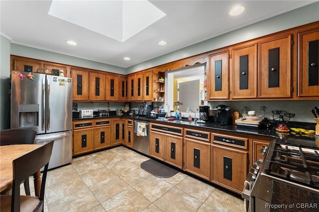 77 Kent Cove Rd, Kilmarnock, VA 22482 - kitchen with stainless steel appliances, brown cabinets, dark countertops, recessed lighting, and glass insert cabinets