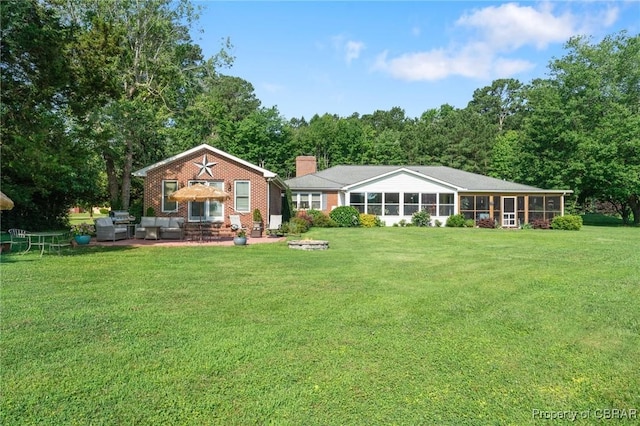 77 Kent Cove Rd, Kilmarnock, VA 22482 - back of house with an outdoor living space, a patio, a lawn, a chimney, and brick siding