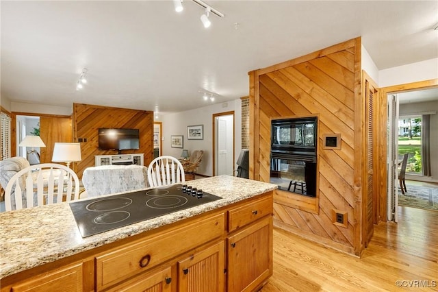 13030 River Hills Dr, Midlothian, VA 23113 - kitchen with black appliances, track lighting, light wood finished floors, open floor plan, and wood walls