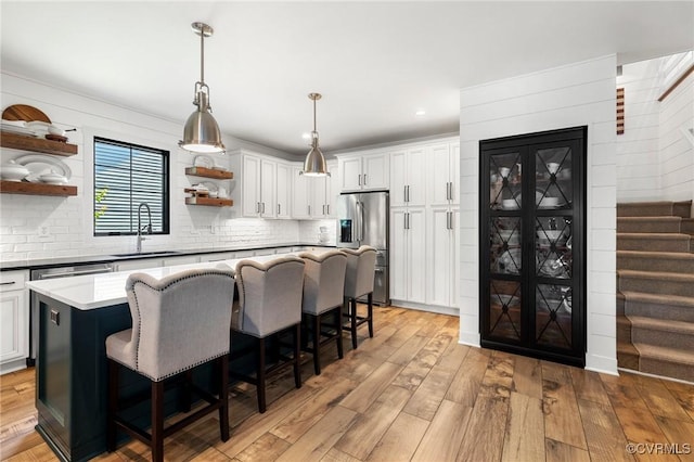 3719 Waverton Dr, Midlothian, VA 23112 - kitchen featuring stainless steel fridge with ice dispenser, open shelves, a kitchen bar, a center island, and light wood finished floors