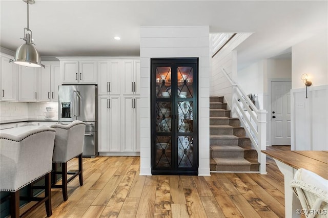 3719 Waverton Dr, Midlothian, VA 23112 - kitchen featuring stainless steel fridge, light wood-style flooring, hanging light fixtures, white cabinets, and a breakfast bar area